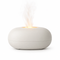 Ivory ultrasonic diffuser with warm flame-effect glow on white background